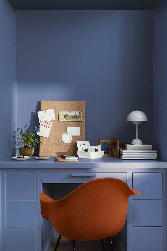 orange chair in front of blue cabinets